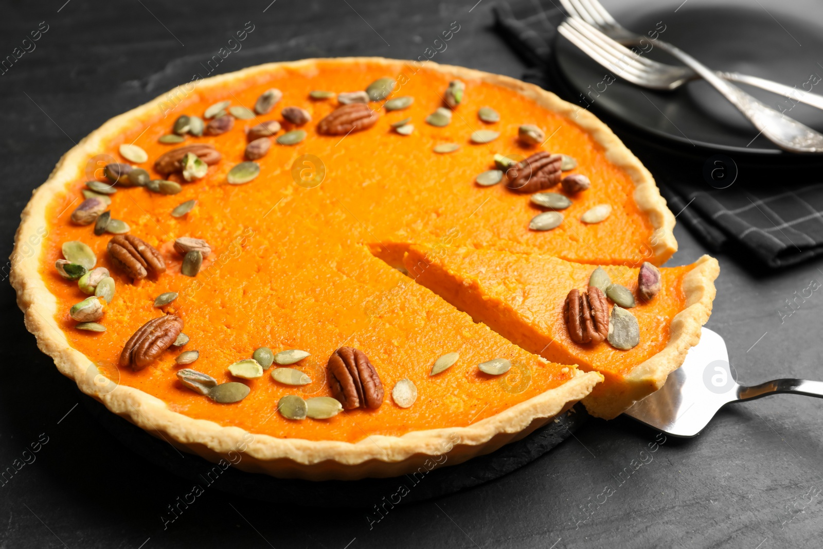 Photo of Delicious homemade pumpkin pie on black table