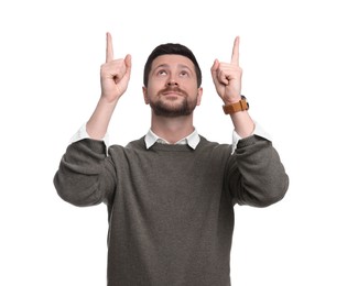 Portrait of handsome bearded businessman pointing at something on white background