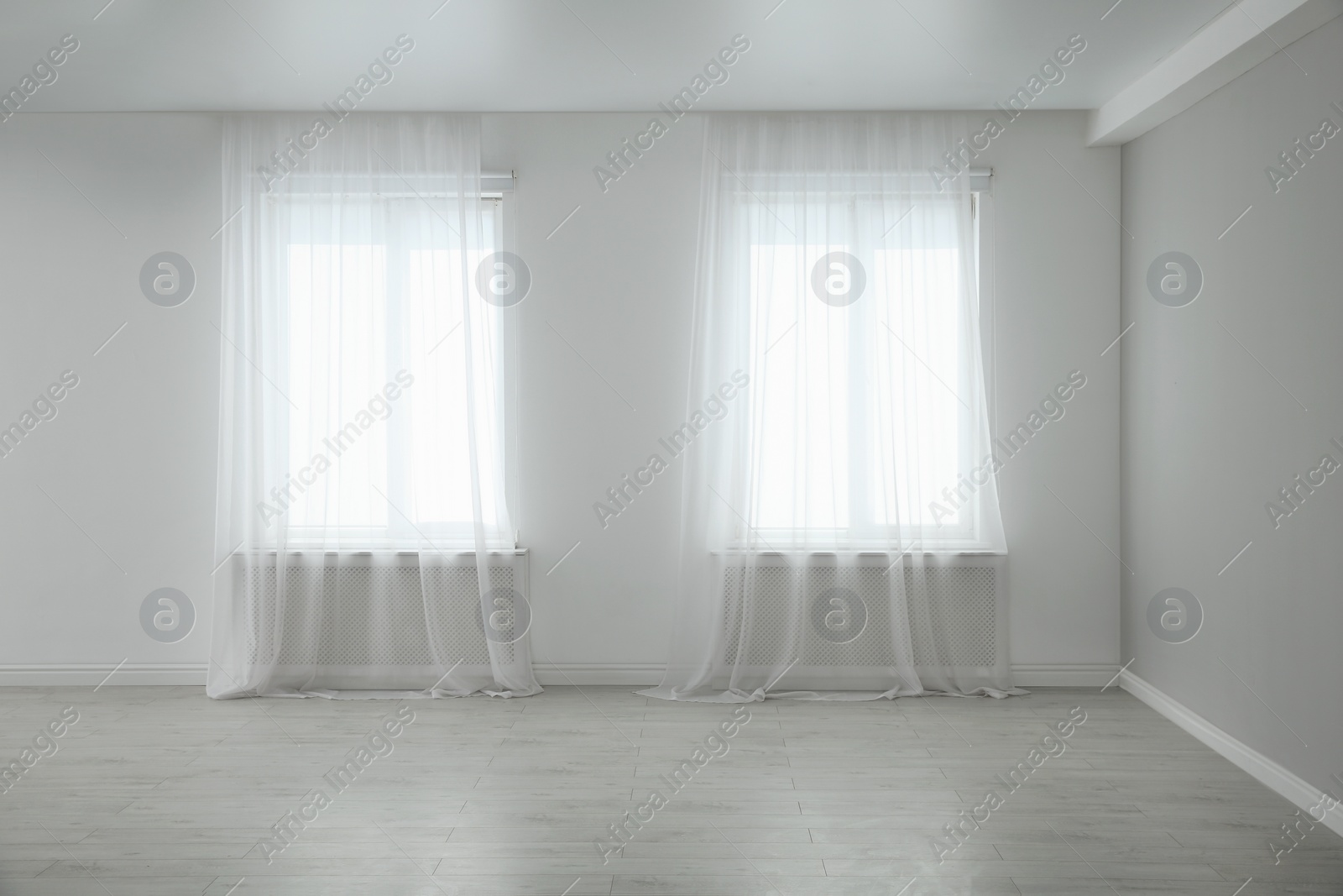 Photo of Empty room with large windows and laminated floor