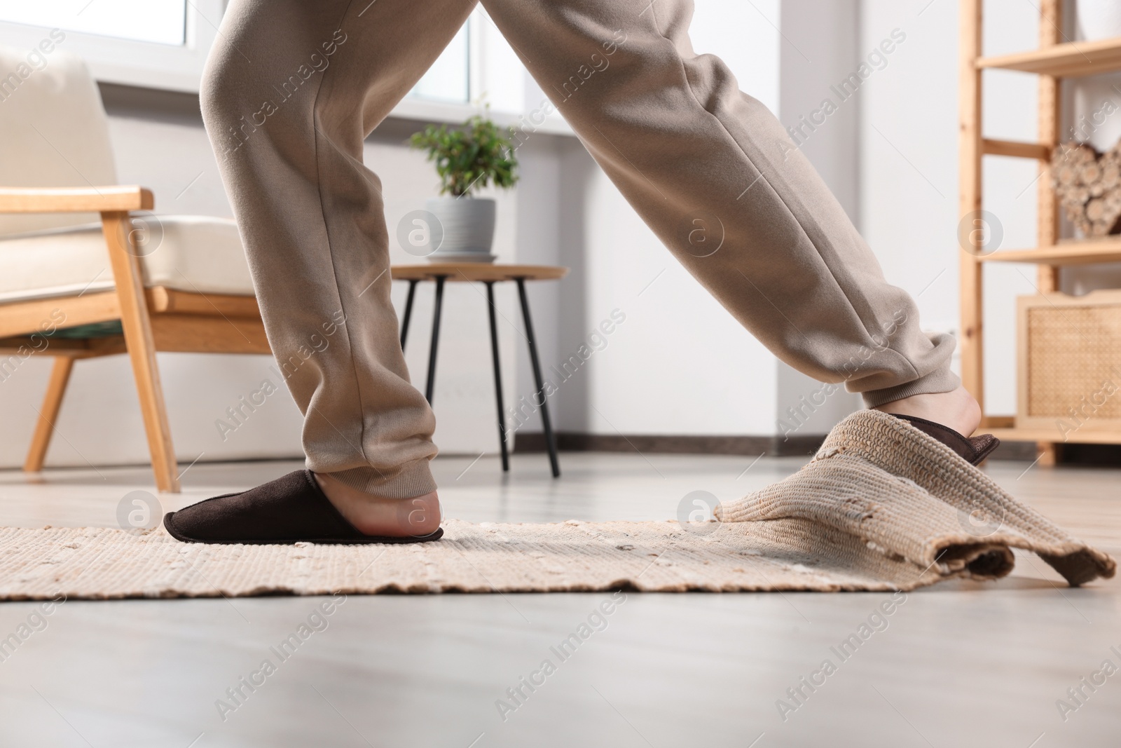 Photo of Man tripping over rug at home, closeup