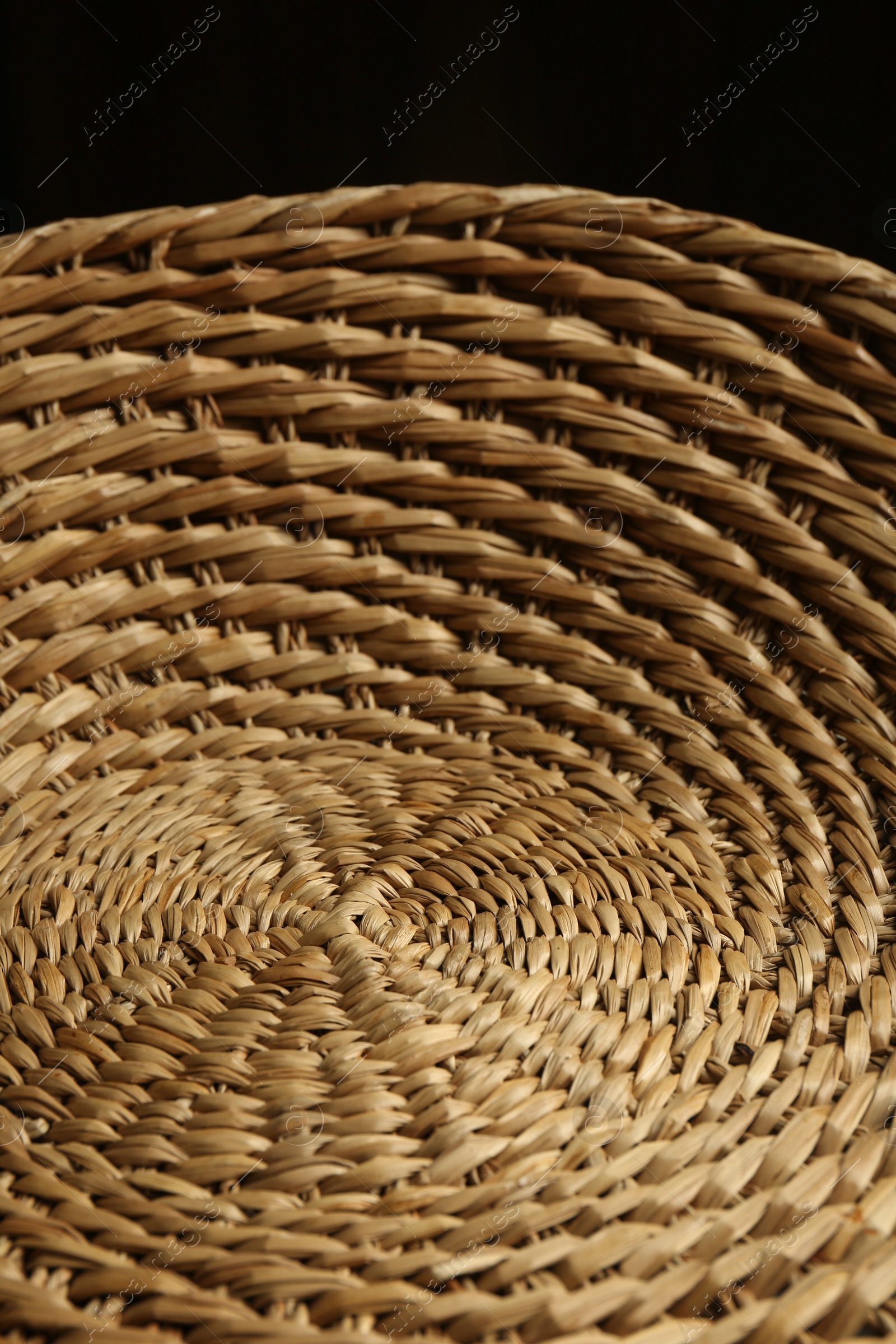 Photo of Empty wicker basket on black background, closeup