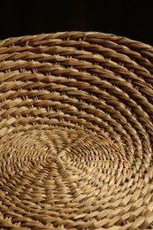 Photo of Empty wicker basket on black background, closeup