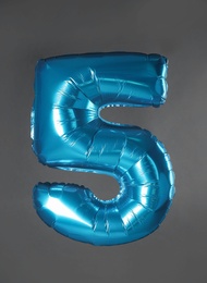 Blue number five balloon on grey background