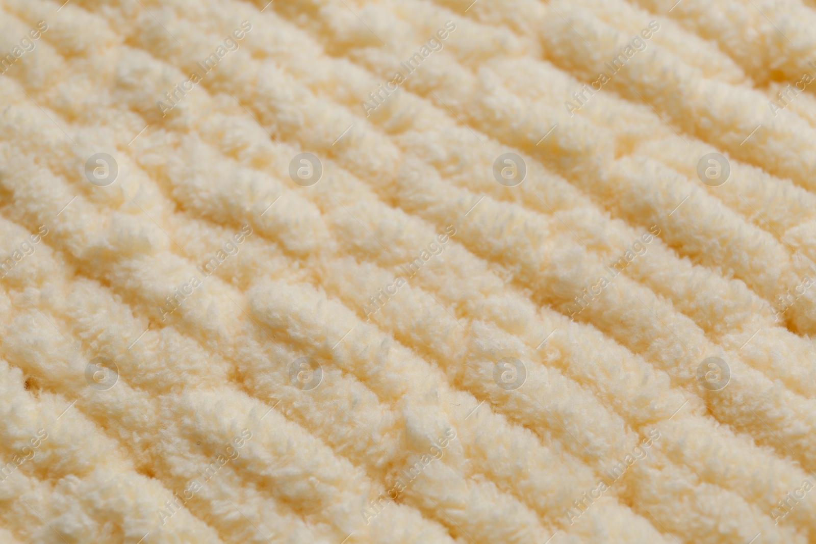 Photo of Soft beige knitted fabric as background, closeup