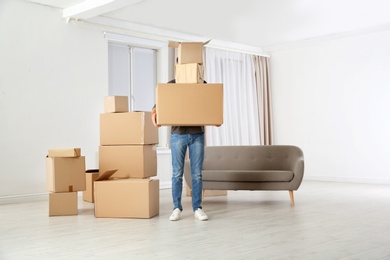 Photo of Man with moving boxes in his new house