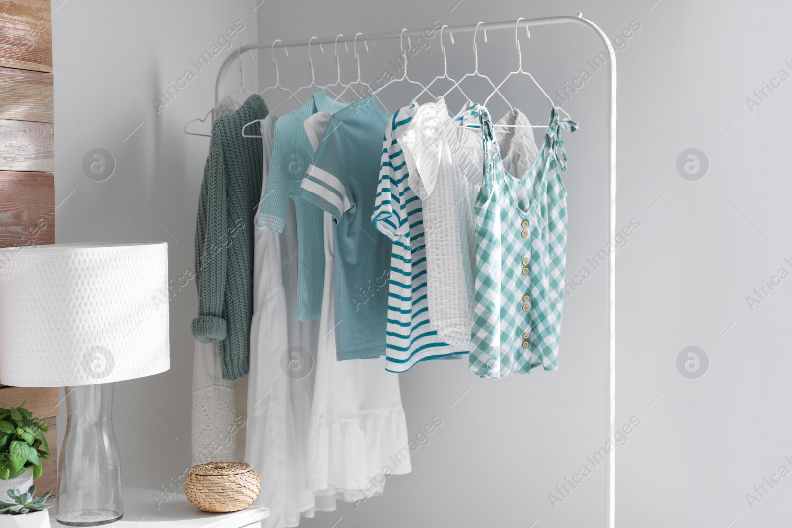 Photo of Rack with stylish women's clothes in modern room. Interior design