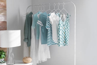 Photo of Rack with stylish women's clothes in modern room. Interior design