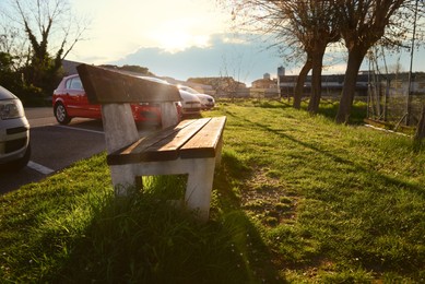 Photo of Wooden bench and green grass outdoors on sunny day
