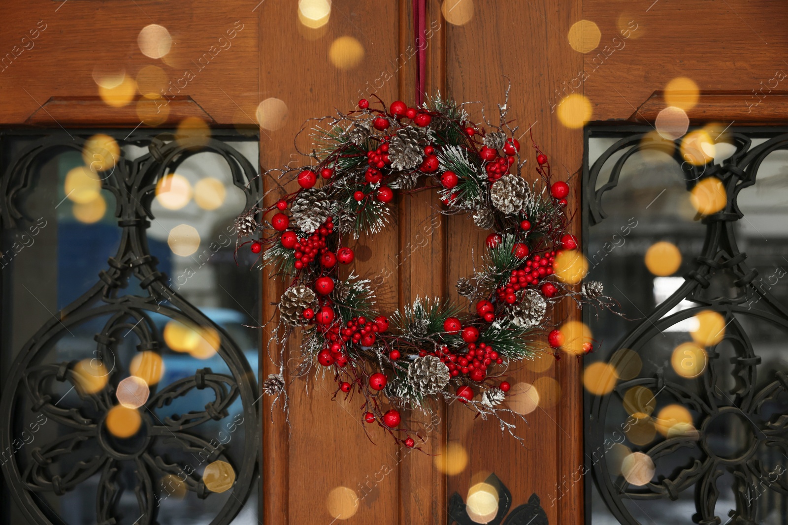 Photo of Beautiful Christmas wreath hanging on wooden door