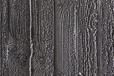 Wooden wall covered with hoarfrost on snowy day, closeup