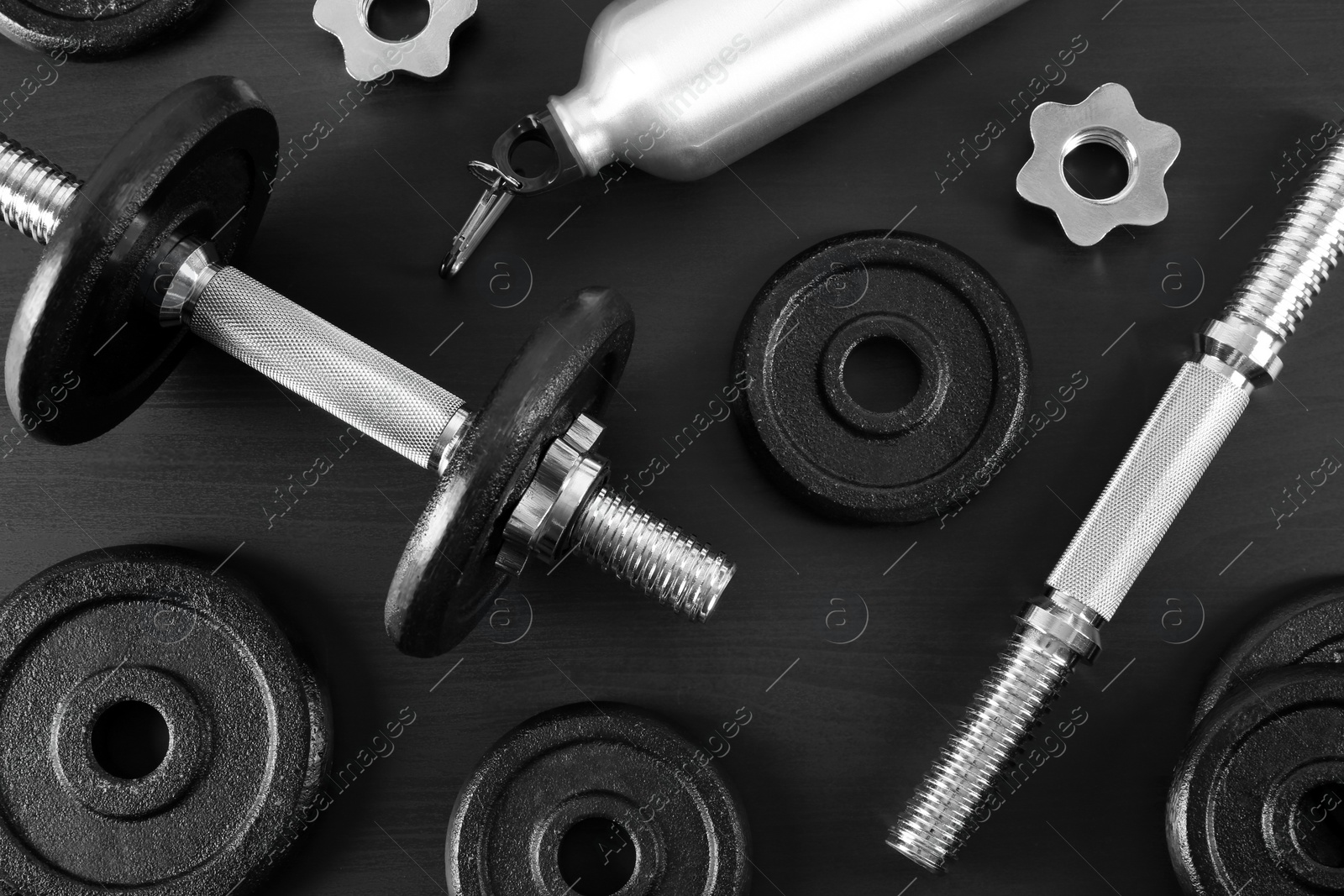 Photo of Flat lay composition with dumbbell and parts on dark wooden background