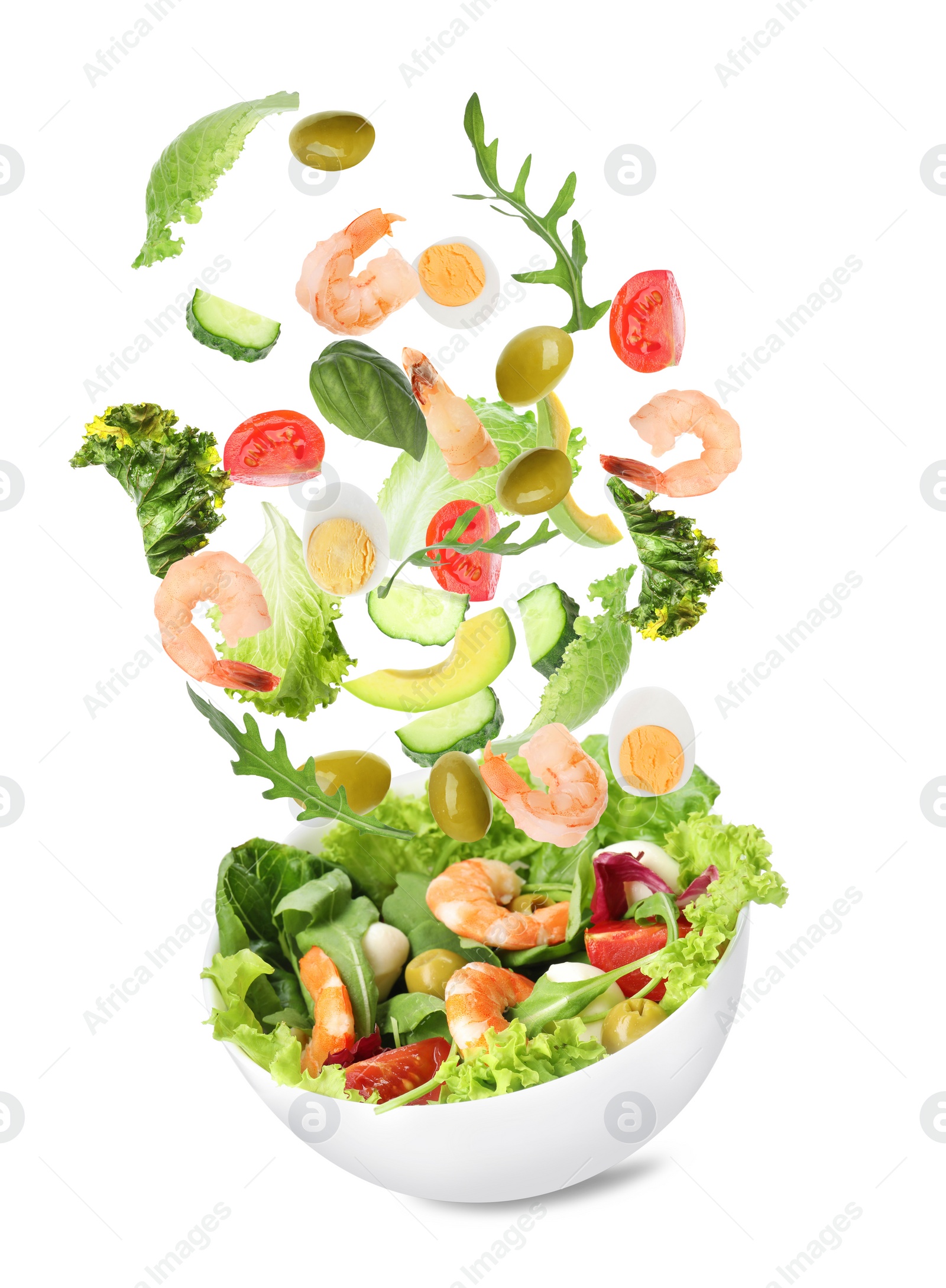 Image of Fresh ingredients for tasty salad falling into bowl on white background 