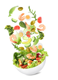 Fresh ingredients for tasty salad falling into bowl on white background 