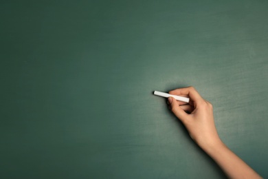 Photo of Woman writing with piece of chalk on board