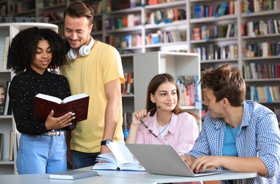 Group of young people studying at table in library