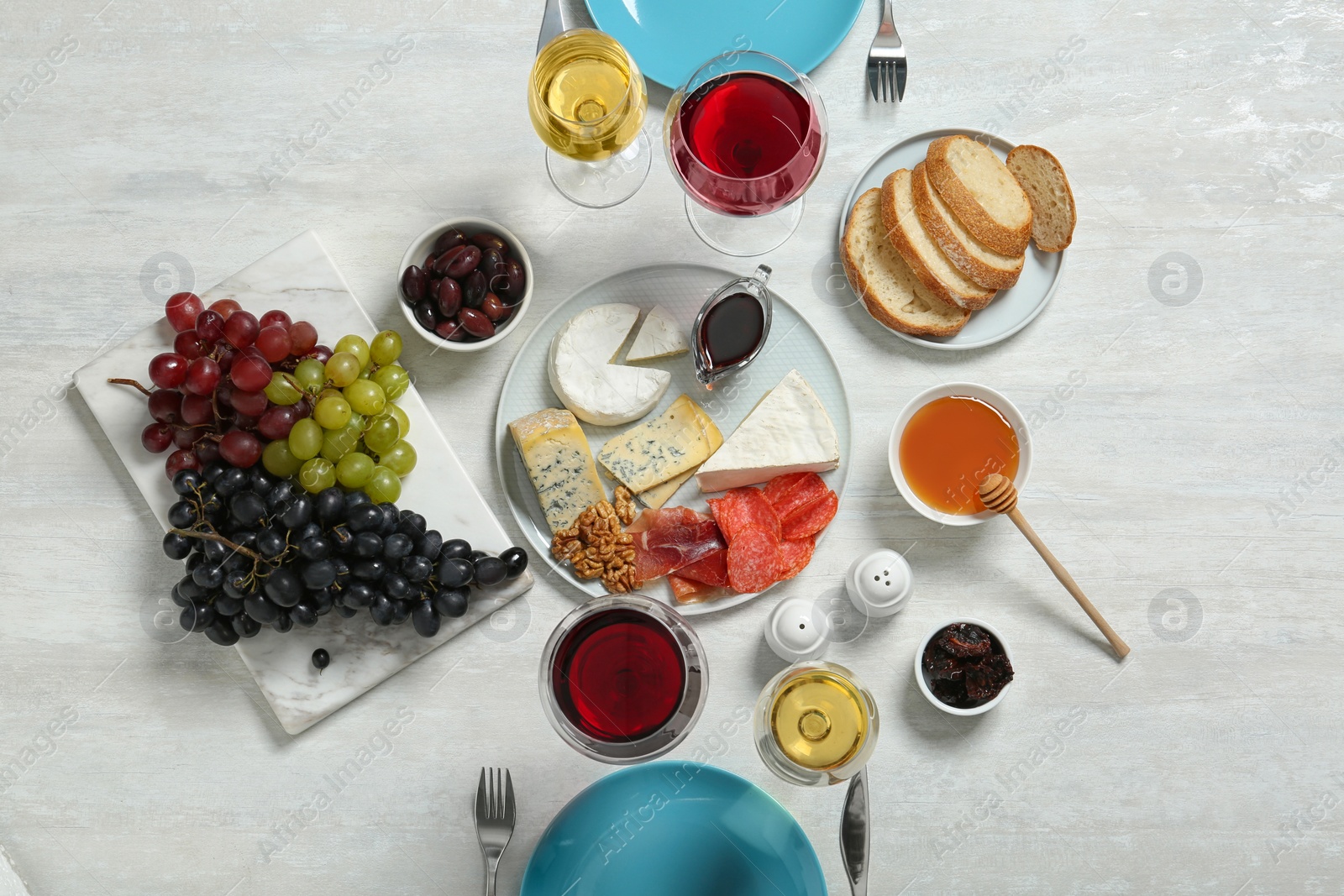 Photo of Wine and snacks served for dinner on light table, top view