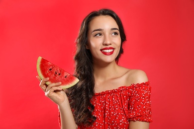 Photo of Beautiful young woman with watermelon on red background