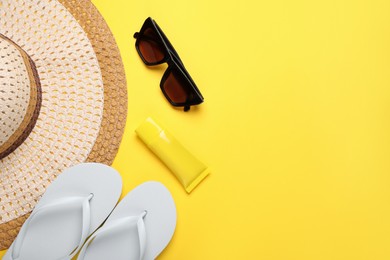 Photo of Flat lay composition with sunscreen and beach accessories on yellow background. Space for text