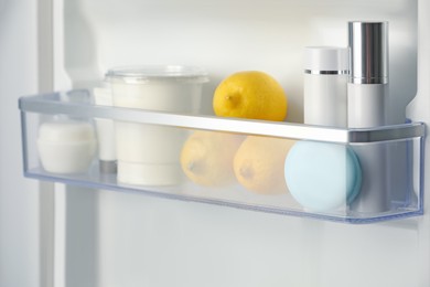 Different cosmetic products on shelf in refrigerator