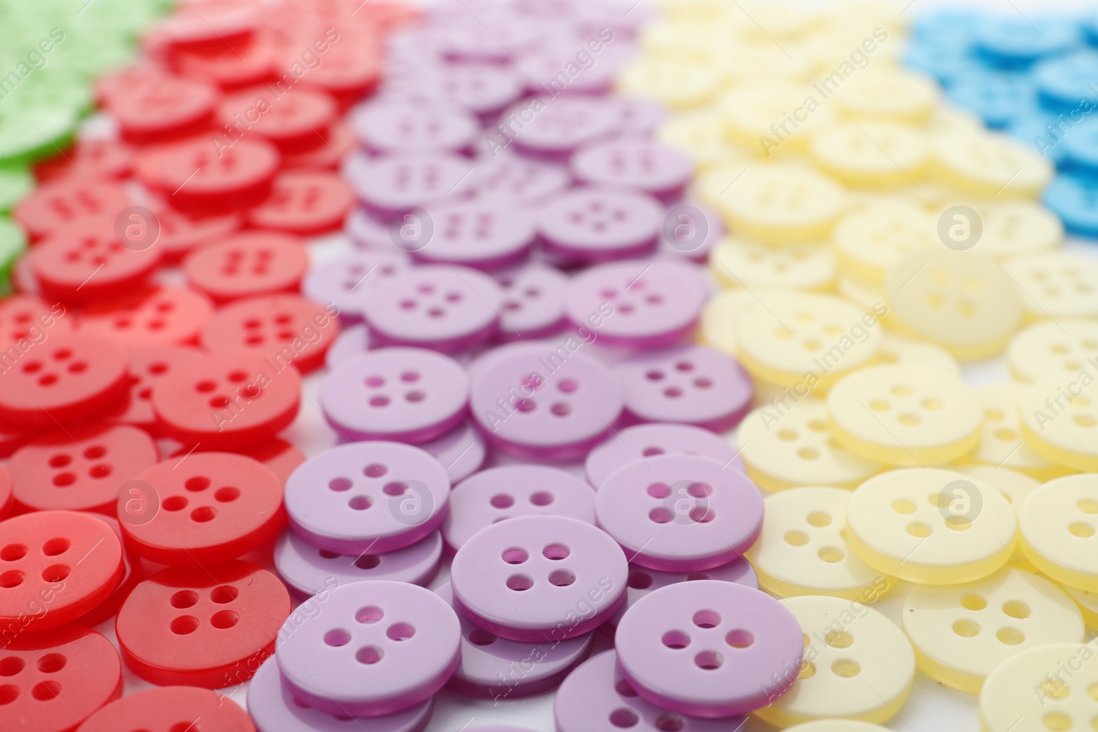 Photo of Many colorful plastic sewing buttons as background, closeup