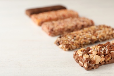 Photo of Tasty protein bars on white table. Space for text