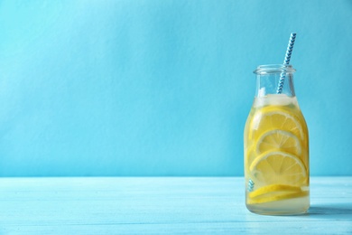 Photo of Natural lemonade with ice in bottle on table