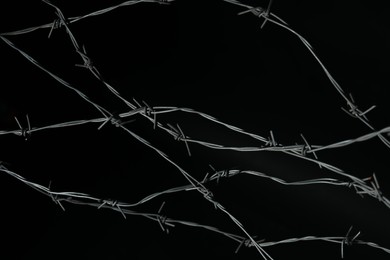 Photo of Shiny metal barbed wire on black background