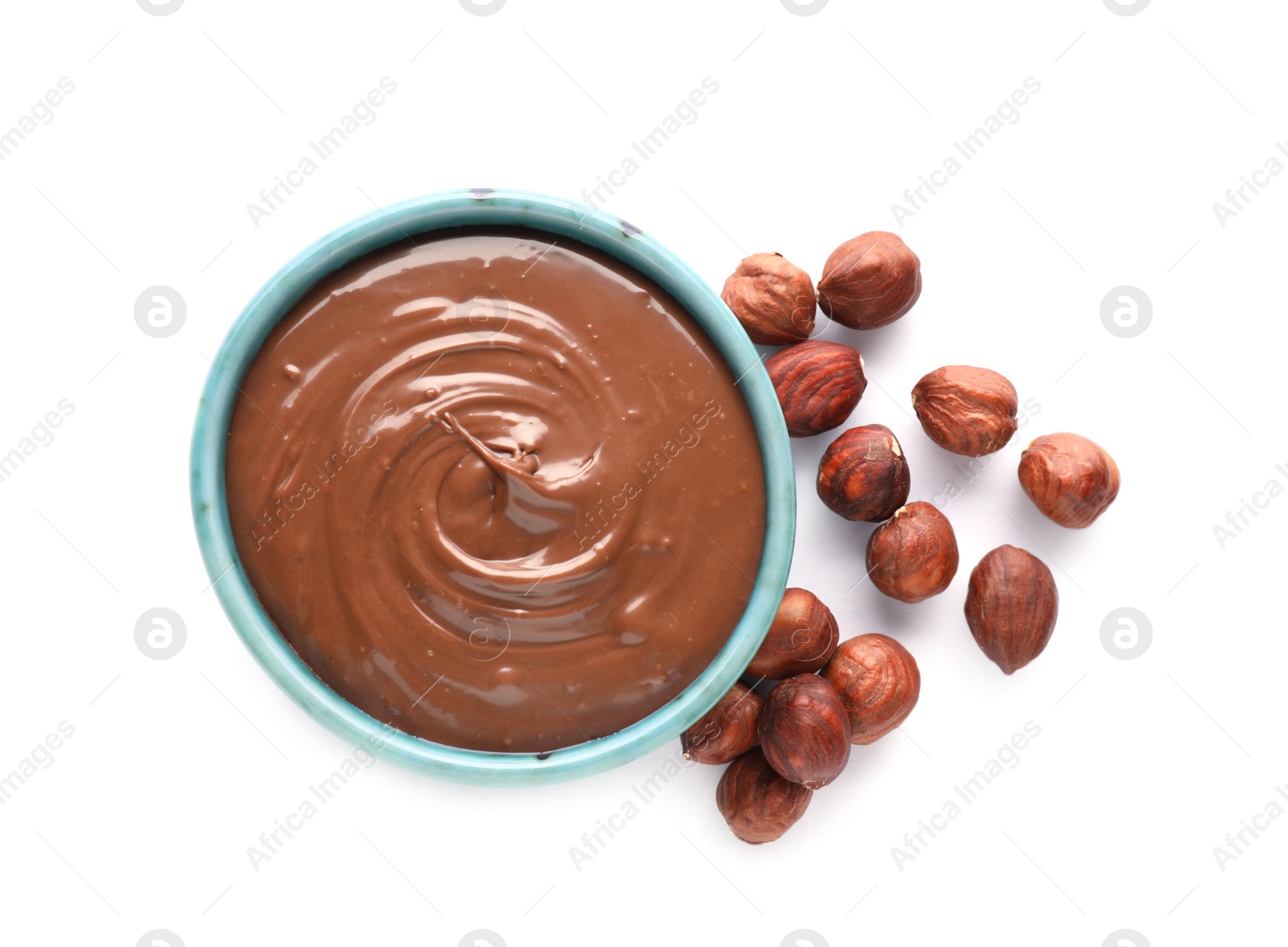 Photo of Bowl with tasty chocolate paste and nuts isolated on white, top view