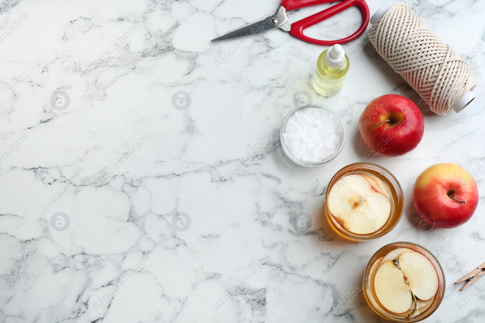 Photo of Flat lay composition with apple candles on marble background. Space for text