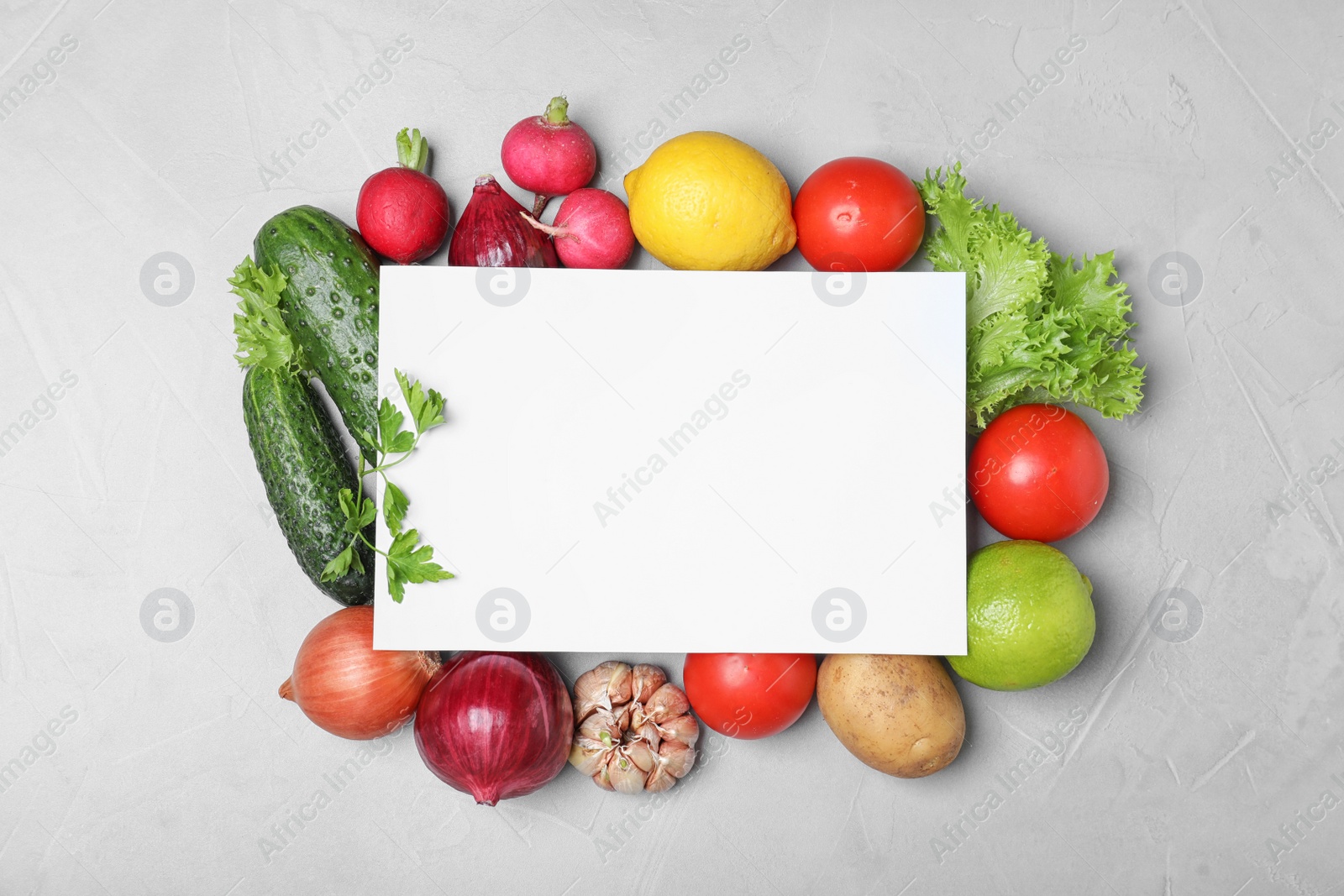 Photo of Fresh fruits and vegetables with blank card on grey background, flat lay. Space for text