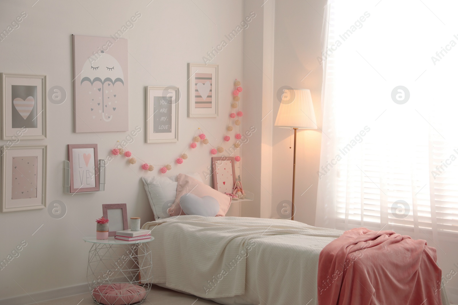 Photo of Modern teenager's room interior with comfortable bed and beautiful pictures