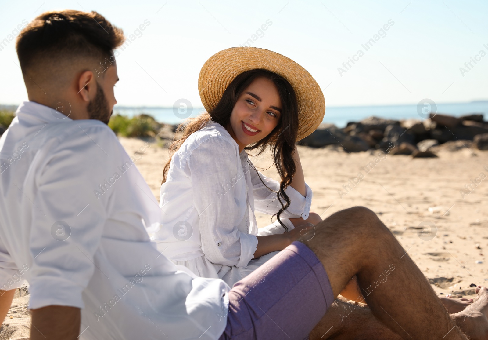 Photo of Happy young couple on beach near sea. Honeymoon trip