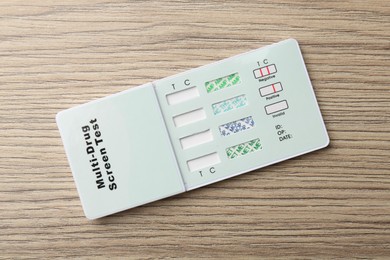 Photo of Multi-drug screen test on light wooden table, top view
