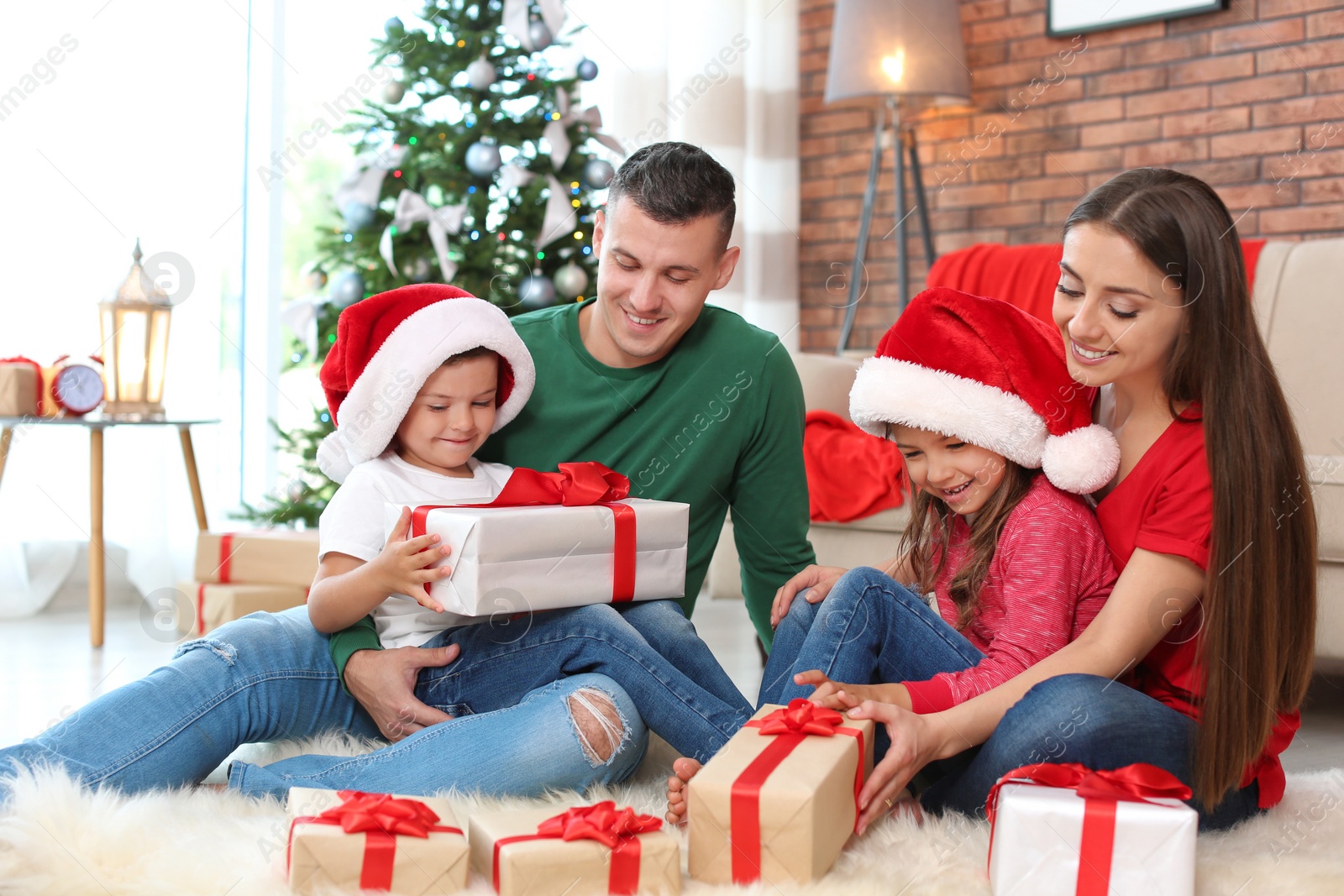 Photo of Happy parents and children exchanging gifts near Christmas tree at home