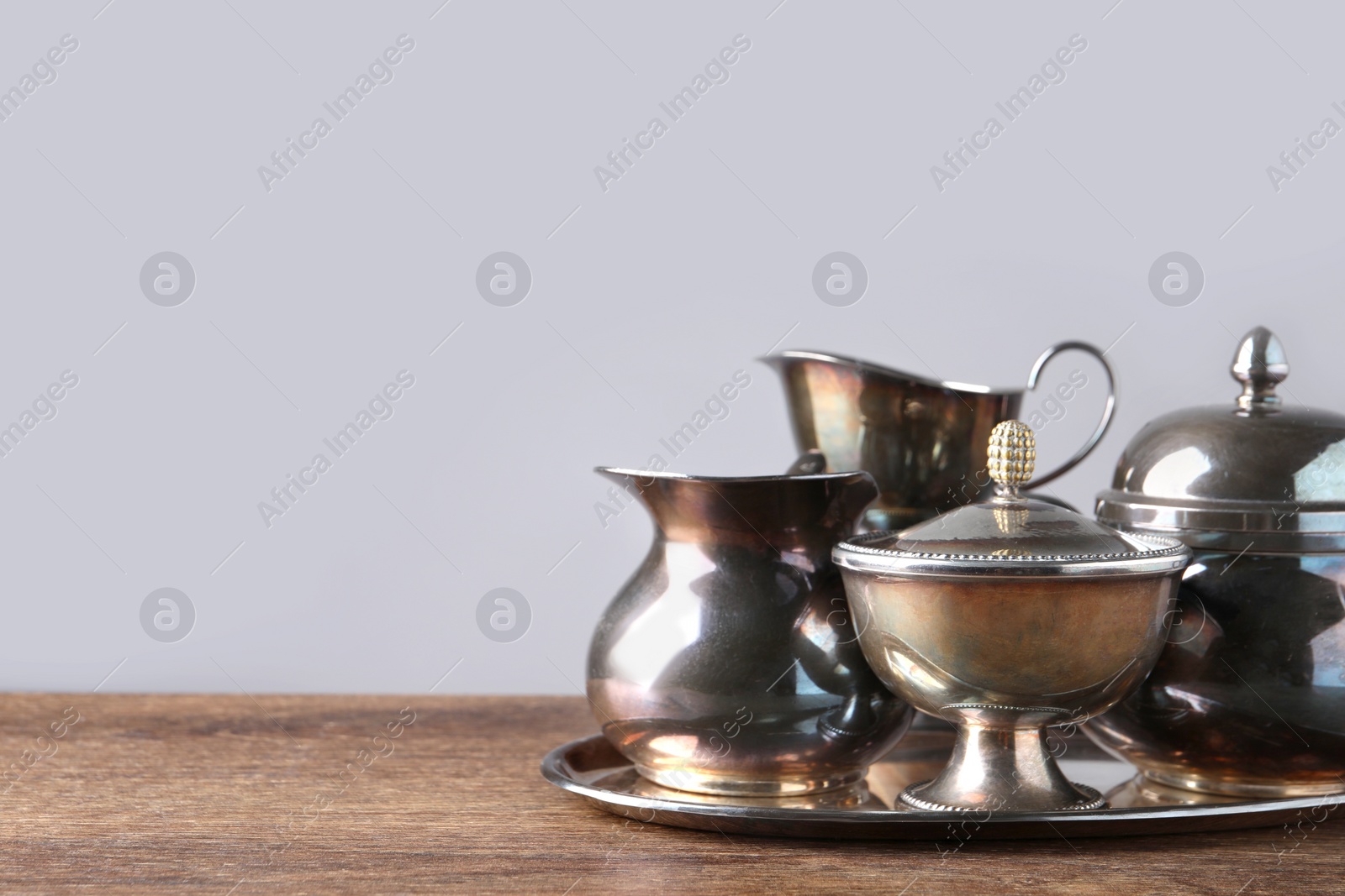 Photo of Tray with beautiful tea set on wooden table, space for text