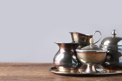 Photo of Tray with beautiful tea set on wooden table, space for text