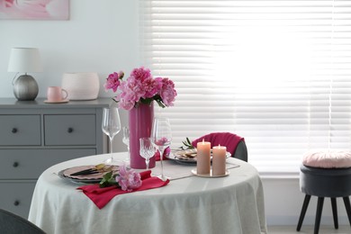 Photo of Beautiful table setting with pink peonies and burning candles