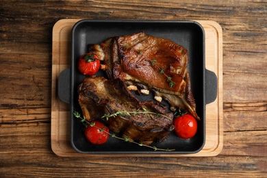 Photo of Delicious roasted ribs served on wooden table, top view