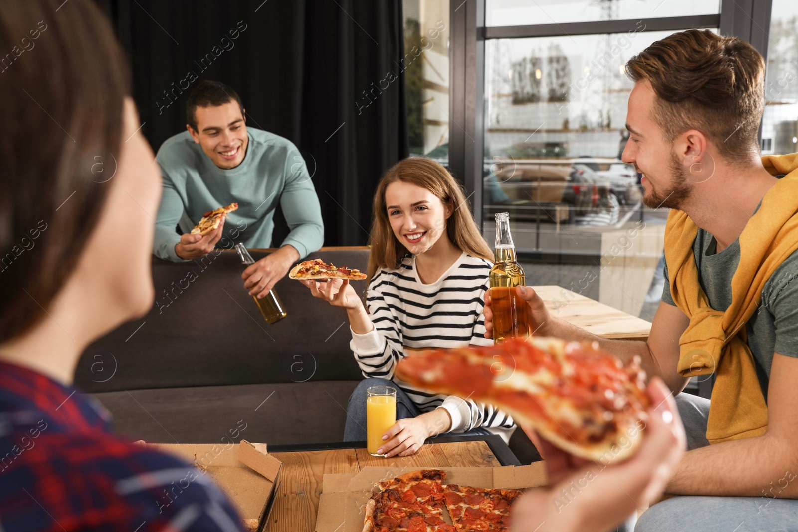 Photo of Group of friends having fun party with delicious pizza in cafe