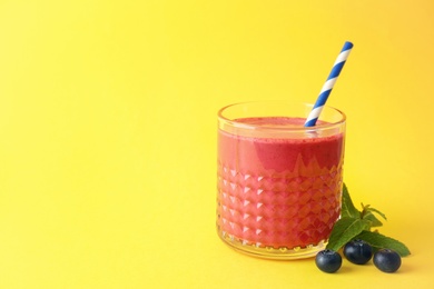 Glass with delicious detox smoothie on color background