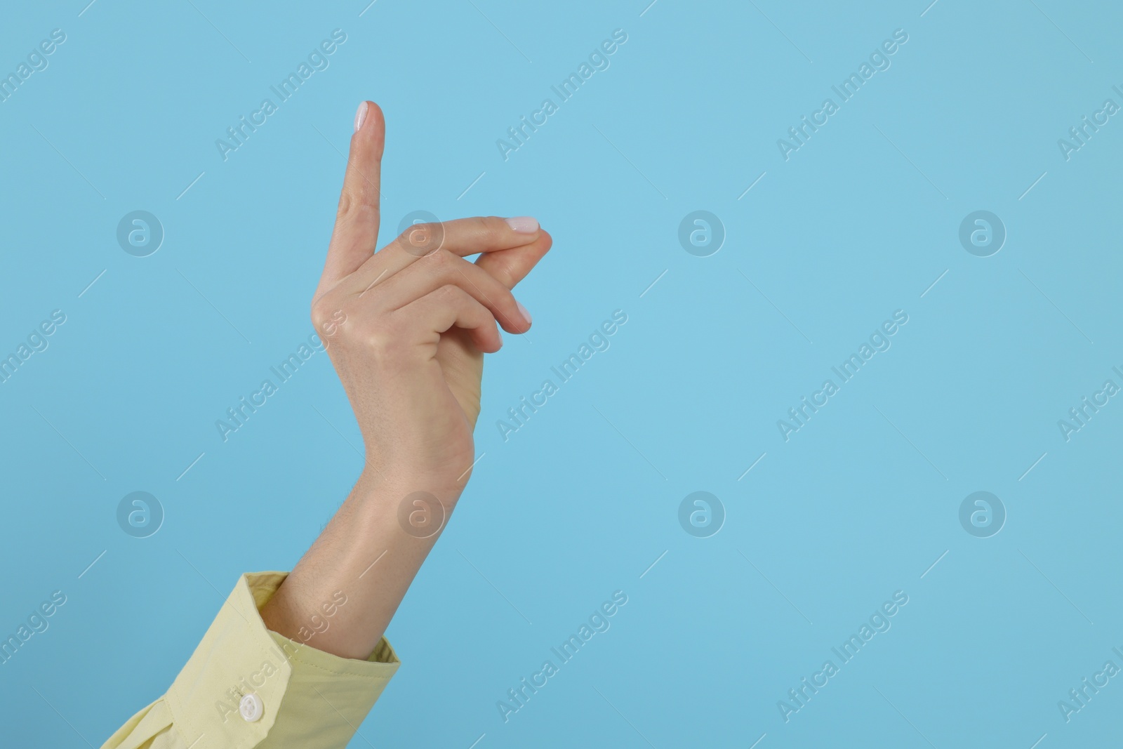 Photo of Woman snapping fingers on light blue background, closeup of hand. Space for text