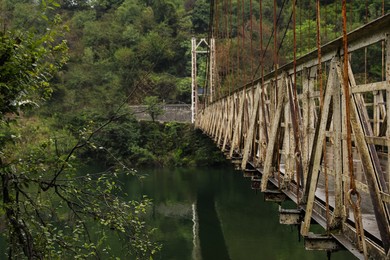 Beautiful view on rusty metal bridge over river in mountains