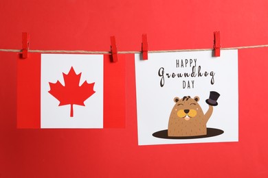 Photo of Happy Groundhog Day greeting card and Canada flag hanging on red background
