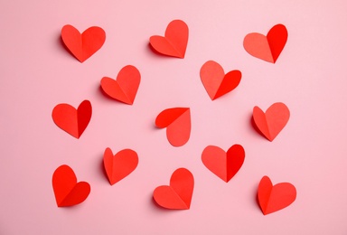 Small paper hearts on color background, top view