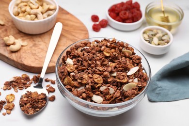 Photo of Tasty granola served with nuts and dry fruits on white marble table