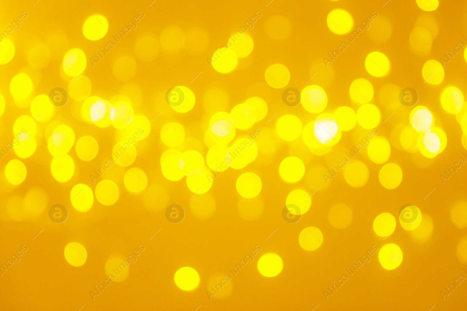 Photo of Blurred view of shiny gold lights. Bokeh effect