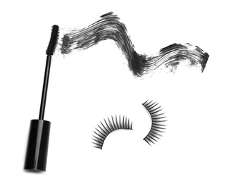 Mascara brush and false eyelashes on white background