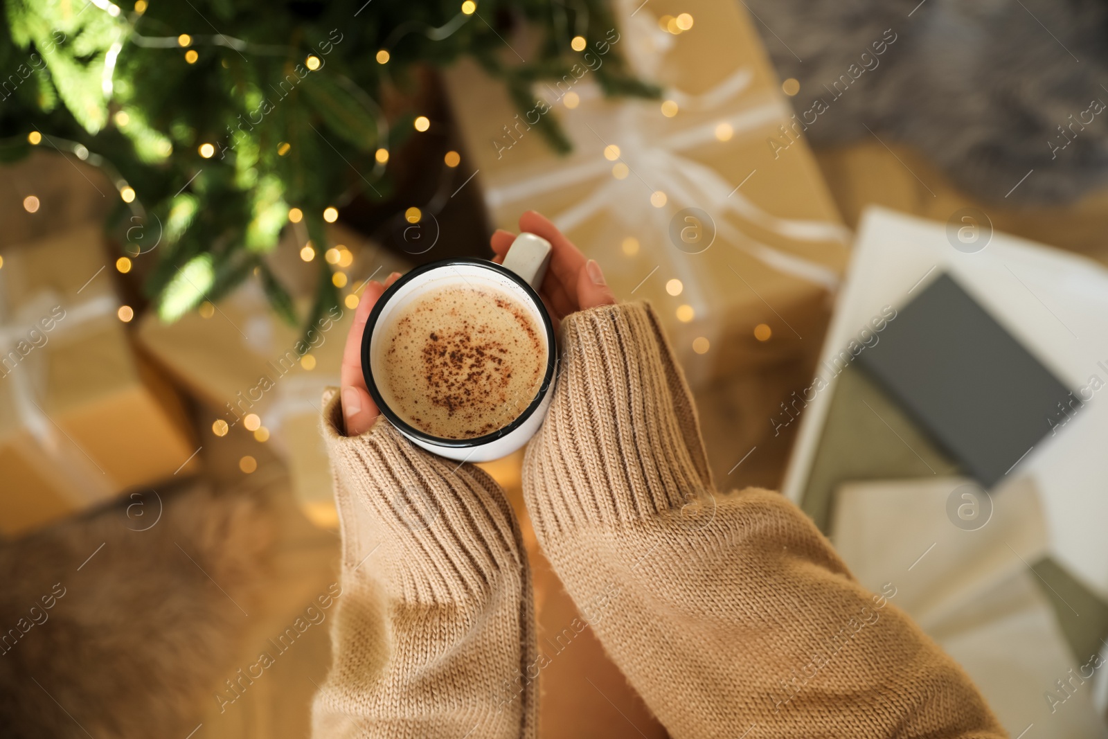Photo of Woman holding cup of cocoa indoors, above view. Christmas mood