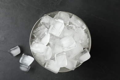 Metal bucket with ice cubes on grey background, flat lay