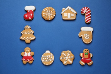 Photo of Frame made with tasty homemade Christmas cookies on blue background, flat lay. Space for text